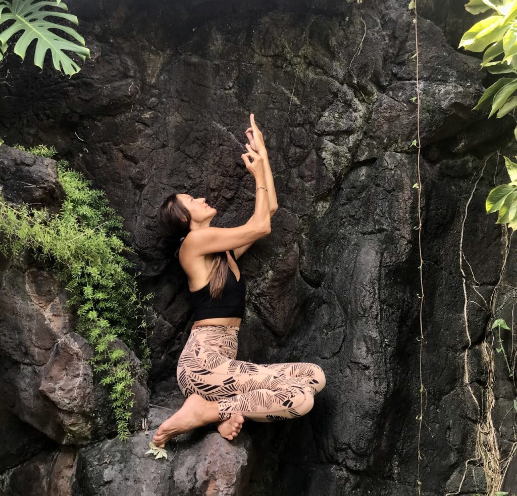 A woman climbing up the side of a rock wall.