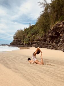 A woman is doing yoga on the beach