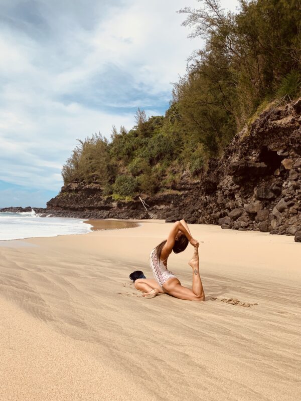 A woman is doing yoga on the beach