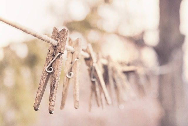 A line of clothes pins hanging on a rope.