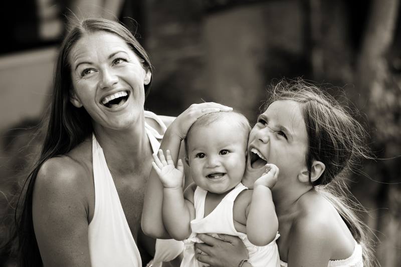 A woman holding a baby and two other women