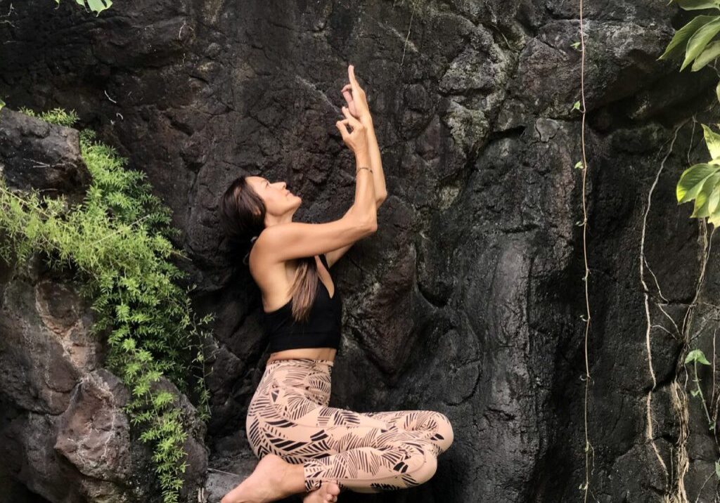 A woman climbing up the side of a rock wall.