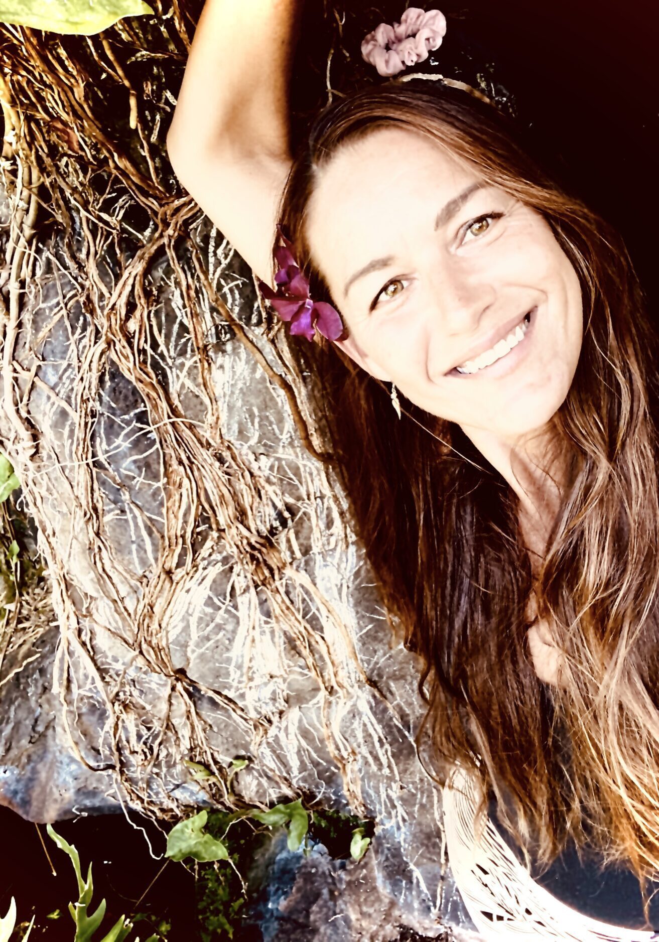 A woman with long hair is smiling for the camera.