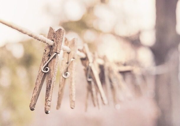 A line of clothes pins hanging on a rope.